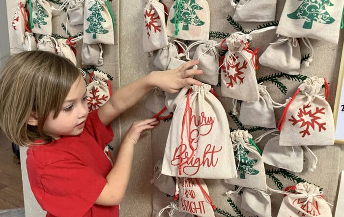 Child interacting with a DIY advent calendar filled with arts and craft activities.