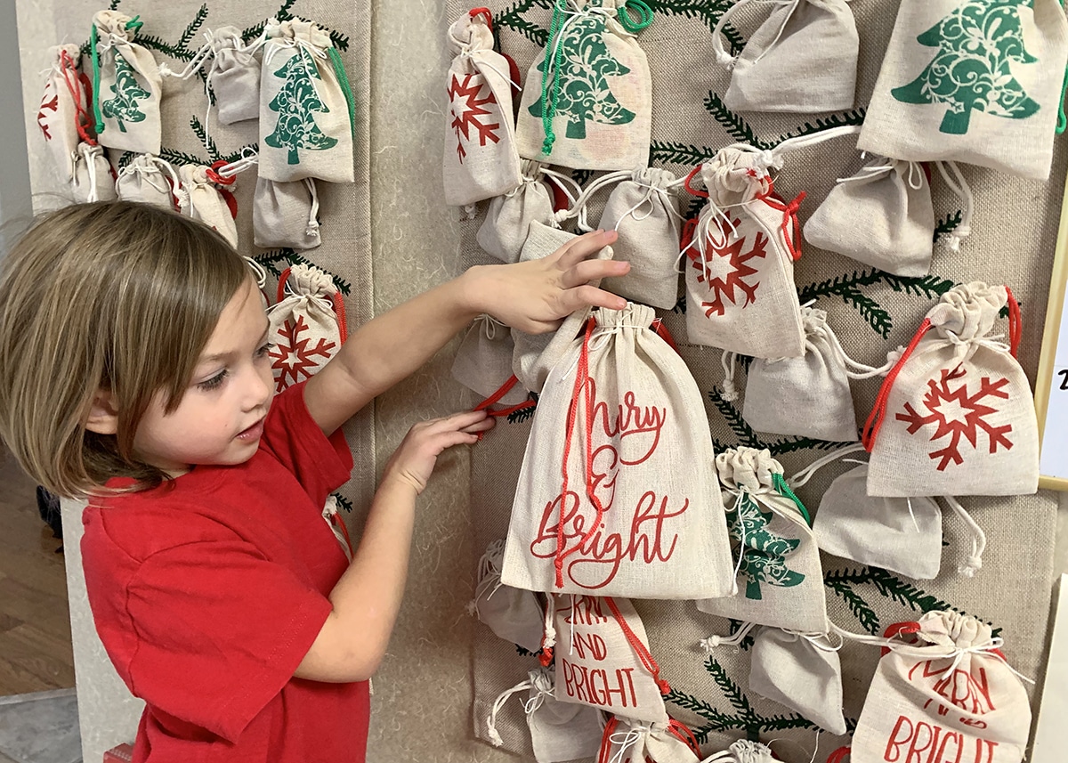 Child interacting with a DIY advent calendar filled with arts and craft activities.