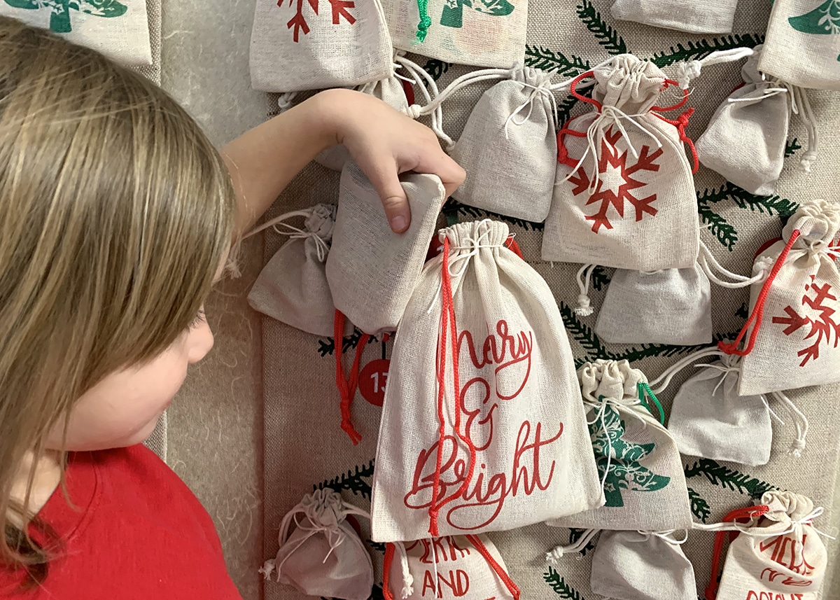 Child interacting with a DIY advent calendar filled with arts and craft activities.