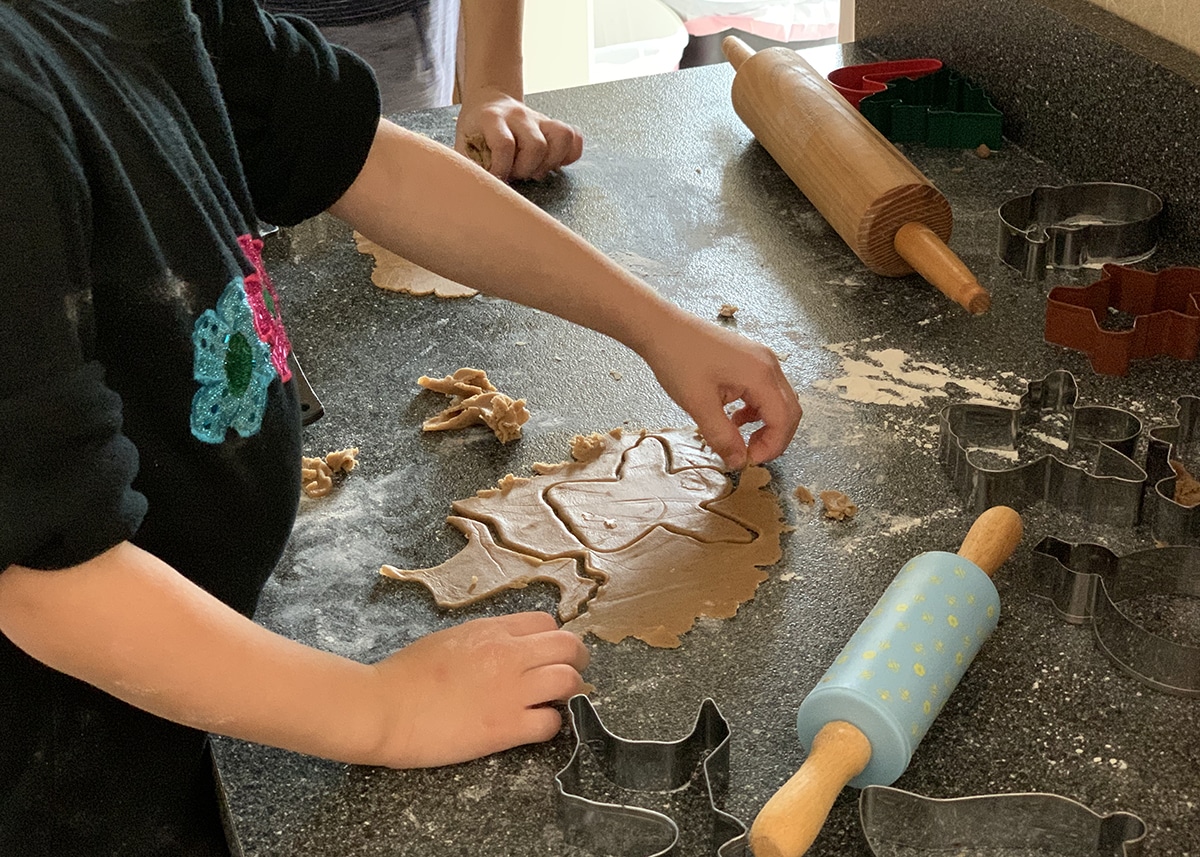 Children rolling and cutting cookie dough for DIY advent calendar baking activity.